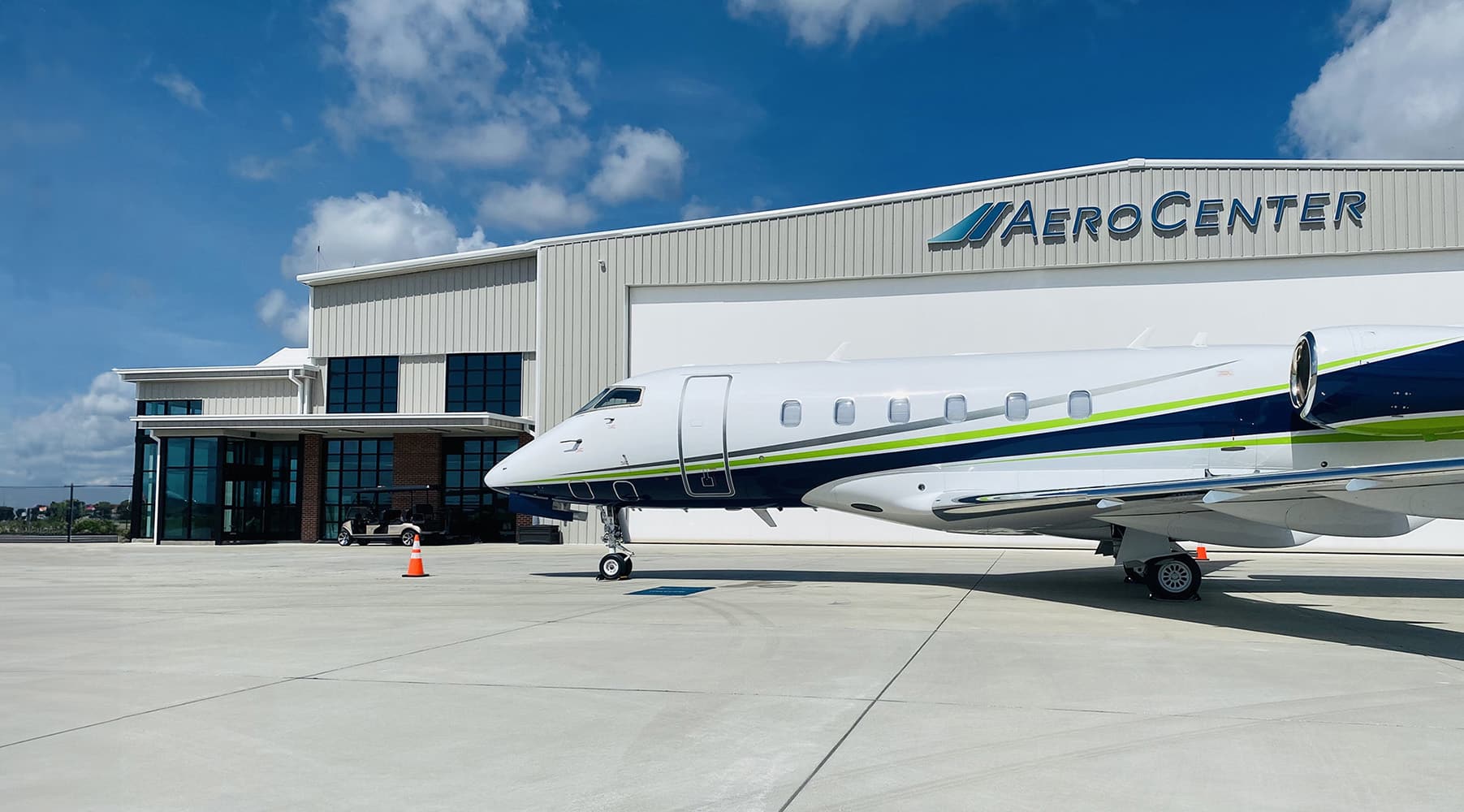 Exterior of Aero Center LAL with a Private Jet in parked on the ramp in front of the hangar